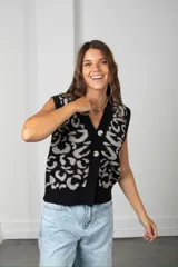 Chaleco tejido de punto con diseño de estampado animal print en contraste de color negro y gris. Presenta escote en V, cierre frontal con botones y corte holgado.
