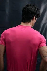 Remera deportiva de compresión color fucsia, con cuello redondo y mangas raglán. Presenta costuras planas antifricción y estampado gráfico en el pecho con la leyenda 365 Training Team.
