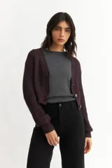 Cárdigan color borgoña de tejido de punto con textura acanalada, escote en V, cierre frontal con botones y mangas largas abullonadas.