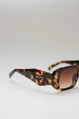 Lentes de sol rectangulares con marco de carey y lentes marrones.