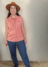 Camisa sin mangas de color salmón, con cuello camisero, cierre frontal con botones y dos bolsillos plaqué en el pecho con solapa.