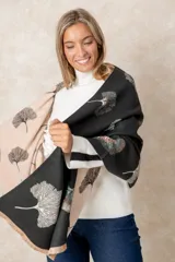 Pashmina reversible de textura suave y caída fluida, con diseño estampado de hojas de ginkgo biloba. Presenta un lado con fondo oscuro y otro con fondo claro, finalizando en ambos extremos con flecos cortos deshilachados.