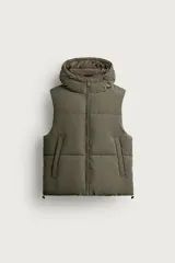 Chaleco acolchado de corte regular fit en color verde militar, con cuello subido, capucha ajustable, cierre frontal de cremallera y bolsillos de vivo en la cadera.
