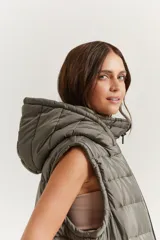 Chaleco verde militar con cierre frontal, bolsillos laterales y capucha forrada.