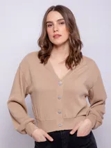 Cárdigan corto color beige, de manga larga y escote en V. Tiene cuatro botones brillantes.