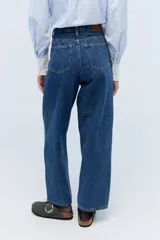 Jean de calce mom, 100% algodón, con lavado azul medio y bordado exclusivo en el interior de la cintura.