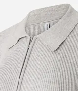 Blusa de viscosa en efecto tricot con superficie acanalada, cuello polo y mangas largas. Cuenta con un lazo decorativo amarillo en el cuello.