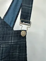 Mono enterito de cuadrillé azul y negro con breteles regulables con hebillas metálicas.