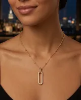 Collar de bronce con baño de oro, diseño de cadena con pequeñas cuentas esféricas y un dije colgante en forma de eslabón alargado completamente pavimentado con circonias.