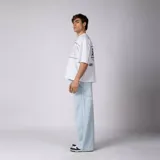 Remera gris oscuro de corte boxy, manga corta amplia, con cuello redondo y diseño gráfico frontal con la palabra "CONCEPTO" delineada en blanco dentro de un panel horizontal.