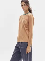 Remera de manga larga con cuello redondo y estampado a rayas horizontales en tonos marrón y negro. Tiene un logo bordado en el pecho de color rojo.