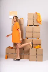 Sandalias bajas con base negra y tiras de cuero color naranja y marrón.