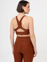 Top deportivo negro, tipo bralette o sujetador deportivo, con escote redondo y tirantes anchos.