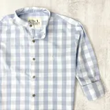 Camisa de algodón a cuadros celestes y blancos, con cuello mao, manga larga y puños abotonados.