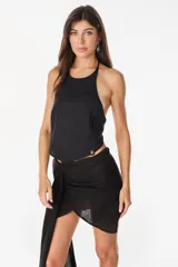Top halter de tencel color beige con silueta asimétrica y diseño minimalista.