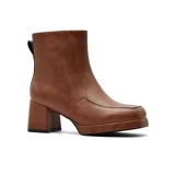 Bota de vestir de caña media en color marrón, con taco cuadrado y plataforma delantera. Presenta un diseño minimalista con costuras visibles y detalle de borde en color negro.