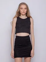 Falda corta negra de tela brillante con textura acanalada y elástico en la cintura.