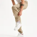 Pantalón cargo color beige, con bolsillos laterales con fuelle y elástico en los tobillos.