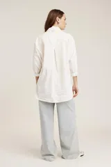 Camisa blanca de corte oversize con detalle de strass aplicado en toda la prenda, cuello camisero clásico y mangas largas con puños.
