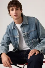 Campera de denim azul con lavado medio, diseño clásico de trucker con bolsillos delanteros con solapa y botones metálicos.