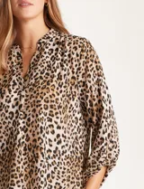 Blusa de gasa con estampado animal print en tonos beige, marrón y negro. Presenta cuello a la base, escote en V y mangas largas con presilla y botón para regular el largo.