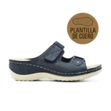 Sandalia azul marino con plantilla de cuero, ajuste con velcro y suela blanca.