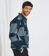 Campera de jacquard de algodón con diseño patchwork de cuadros en tonos azules. Presenta cuello inglés, cierre frontal con botones metálicos, mangas largas y bolsillos delanteros.