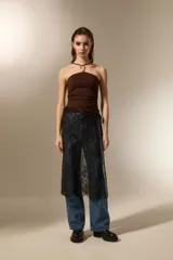 Falda midi negra de poliamida, con diseño de encaje floral y anudado en la cintura.