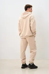 Pantalón de jogging color beige, con cintura elástica ajustable con cordón, bolsillos laterales y corte holgado.