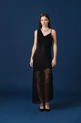 Vestido largo negro con escote drapeado, un solo bretel y falda con paneles de encaje transparente en la parte inferior.