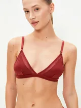 Bralette de diseño triangular en color bordó, confeccionado en tela satinada con detalles de transparencias en los bordes de las copas. Cuenta con breteles finos regulables y cierre posterior.