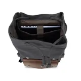 Mochila de tela canvas color negro con solapa y detalles en cuero sintético marrón. Presenta un cierre superior tipo marinero con cordón ajustable, solapa principal con correas y hebillas, y un bolsillo frontal con solapa. Posee bolsillos laterales con cierre metálico y correas de hombro ajustables.