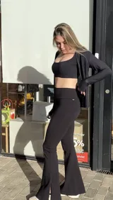 Calza negra acampanada con aberturas laterales y bolsillo interno en la cintura.