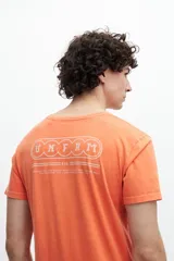 Remera naranja de algodón con estampa en la espalda que incluye texto y el logo de la marca.