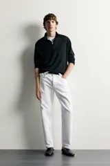 Jeans regular fit de corte recto y tiro medio, confeccionados en denim de algodón blanco con diseño de cinco bolsillos y cierre frontal con cremallera y botón.