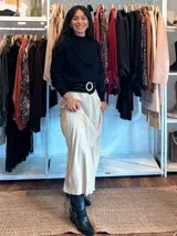 Falda midi de satén en color negro, con corte al bies y caída fluida que se ajusta suavemente a la silueta.