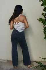 Jean tiro alto de algodón denim color celeste, con cuatro bolsillos, cierre de botón y cremallera, y diseño de pierna recta.