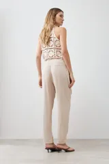 Pantalón de pijama de lino color beige melange, con cintura elástica ajustable con cordón y pespuntes en contraste.