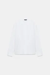 Camisa blanca de popelín con cuello solapa, manga larga y cierre frontal con botones ocultos por solapa.