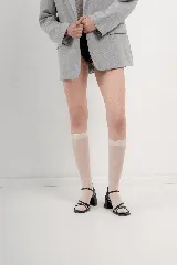 Sandalia de cuero metalizado color naranja/piel con plantilla cuadrada y taco de 5 cm. Presenta un diseño de tiras finas cruzadas en la parte delantera y tira de ajuste en el tobillo.