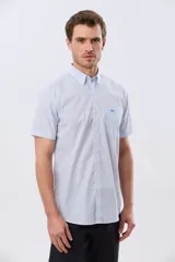 Camisa de manga corta a rayas celestes y blancas, con cuello abotonado, bolsillo frontal en el pecho con logo bordado y cierre frontal de botones.