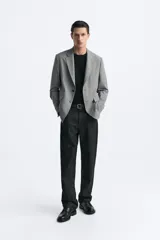 Blazer azul marino de corte recto, confeccionada en tejido con viscosa. Tiene cuello con solapas de muesca, manga larga con puño abotonado, bolsillo de vivo en el pecho y bolsillos de parche en la cadera. El bajo tiene aberturas en la espalda y el cierre es con botonadura frontal.