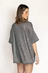 Remera oversize gris con acabado brillante metalizado, mangas cortas y corte holgado.
