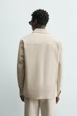 Sobrecamisa de algodón color beige claro, de corte relajado, con cuello solapa, manga larga y dos bolsillos de plastrón en el pecho.