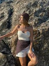 Bandana triangular tejida a crochet con hilo de algodón color marrón.