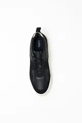 Zapatillas urbanas negras con detalles en gamuza y suela blanca.