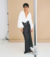 Pollera recta modelo new midi, confeccionada en satén negro sin estampado y con cintura elástica.