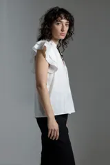 Blusa color crudo de tela satinada con escote en V y mangas cortas con volados.