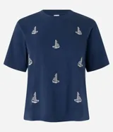Blusa azul marino de algodón con cuello redondo y mangas cortas. Presenta bordados de barcos de vela en la parte delantera.