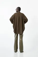 Pantalón de tiro medio con calce recto y largo hasta el tobillo, confeccionado en material con efecto piel o vinilo, color verde oliva brillante.